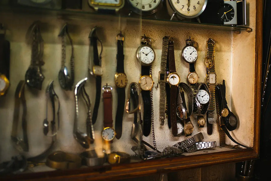 Vintage and antique watch display featuring classic dress watches with leather straps and gold tone cases