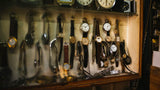 Vintage and antique watch display featuring classic dress watches with leather straps and gold tone cases